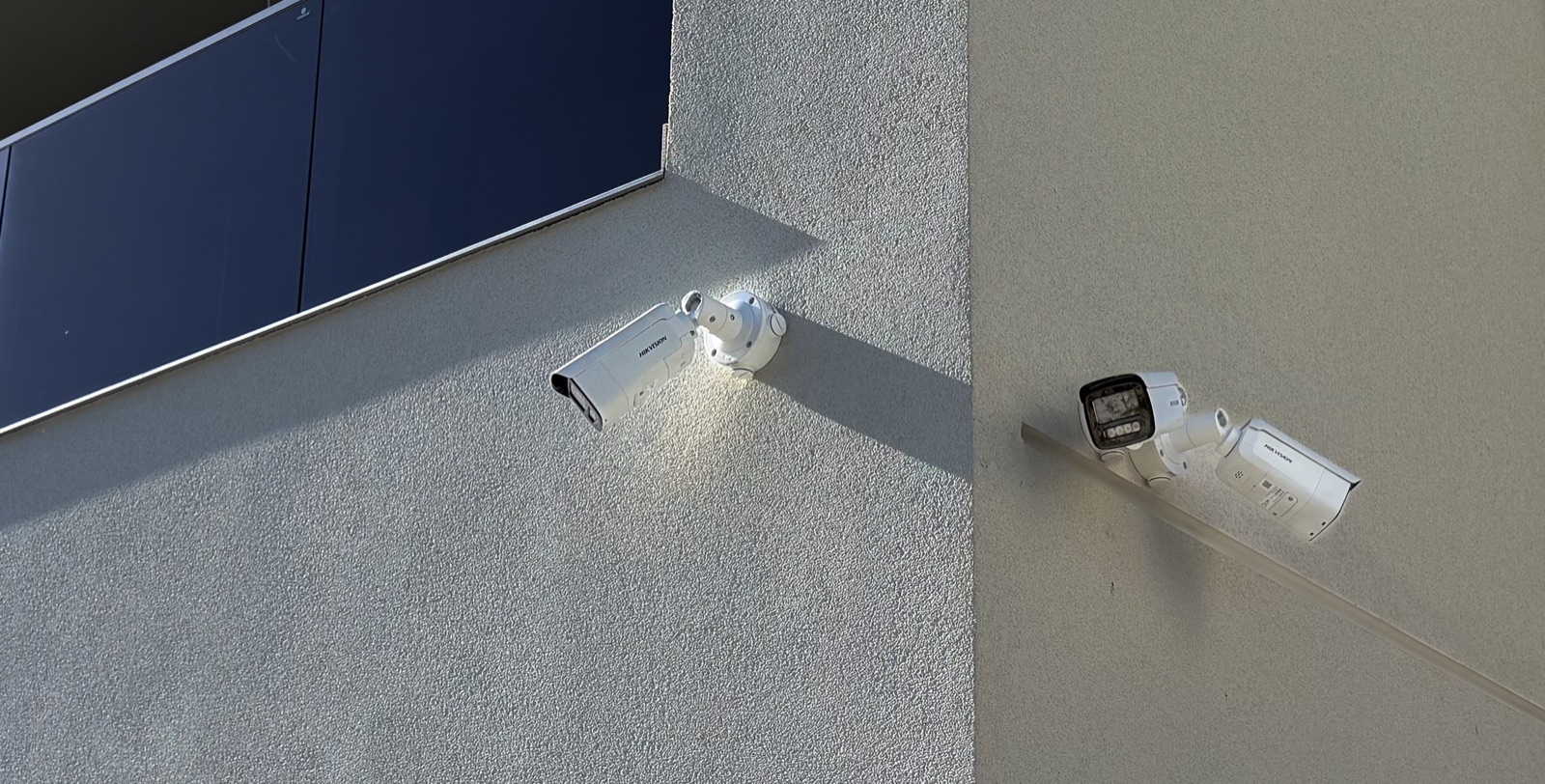 Două camere bullet pe colțul unei case — supraveghere exterior